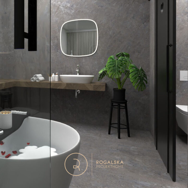 Wjeście z sypialni do łazienki wykończonej kamieniem. Toaleta znajduje się za czarnymi, pełnymi, przesuwnymi drzwiami z wyciętym sercem.