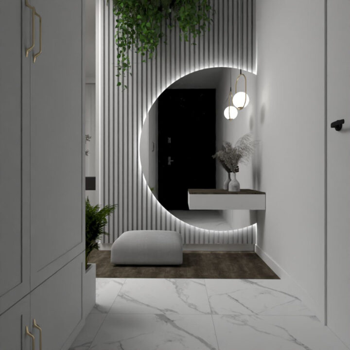 Duże okrągłe lustro z podświetleniem LED w wiatrołapie apartamentu w stylu Modern Classic z elementami Boho, zawieszone na ścianie wykończonej lamelami. Wnętrze w odcieniach bieli z dodatkami złota.