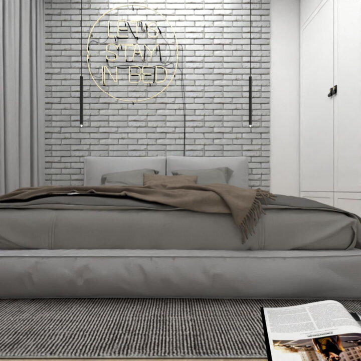 Nowoczesna sypialnia w apartamencie na wynajem z elementami loftowymi w postaci szarej cegiełki na ścianie oraz dopełniającego całości neonu.